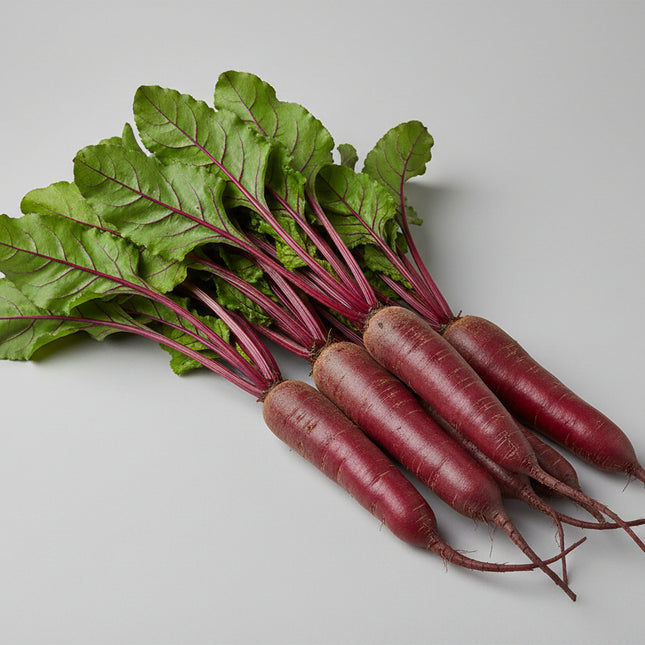 Beets with green leaves on a wooden surface