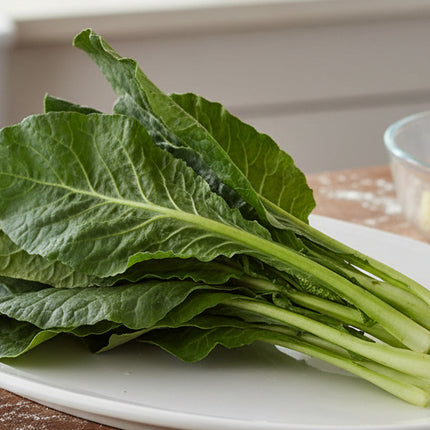 Bunch of green leafy vegetables on a white background
